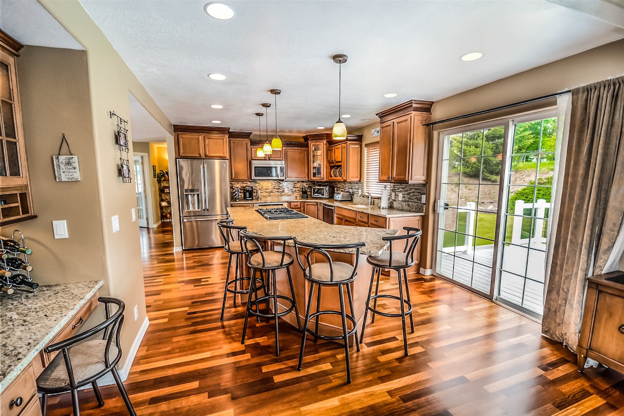 services-04 A luxurious modern kitchen featuring hardwood floors and granite countertops.